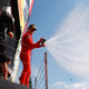 Charles Leclerc sprays champagne from the podium.
